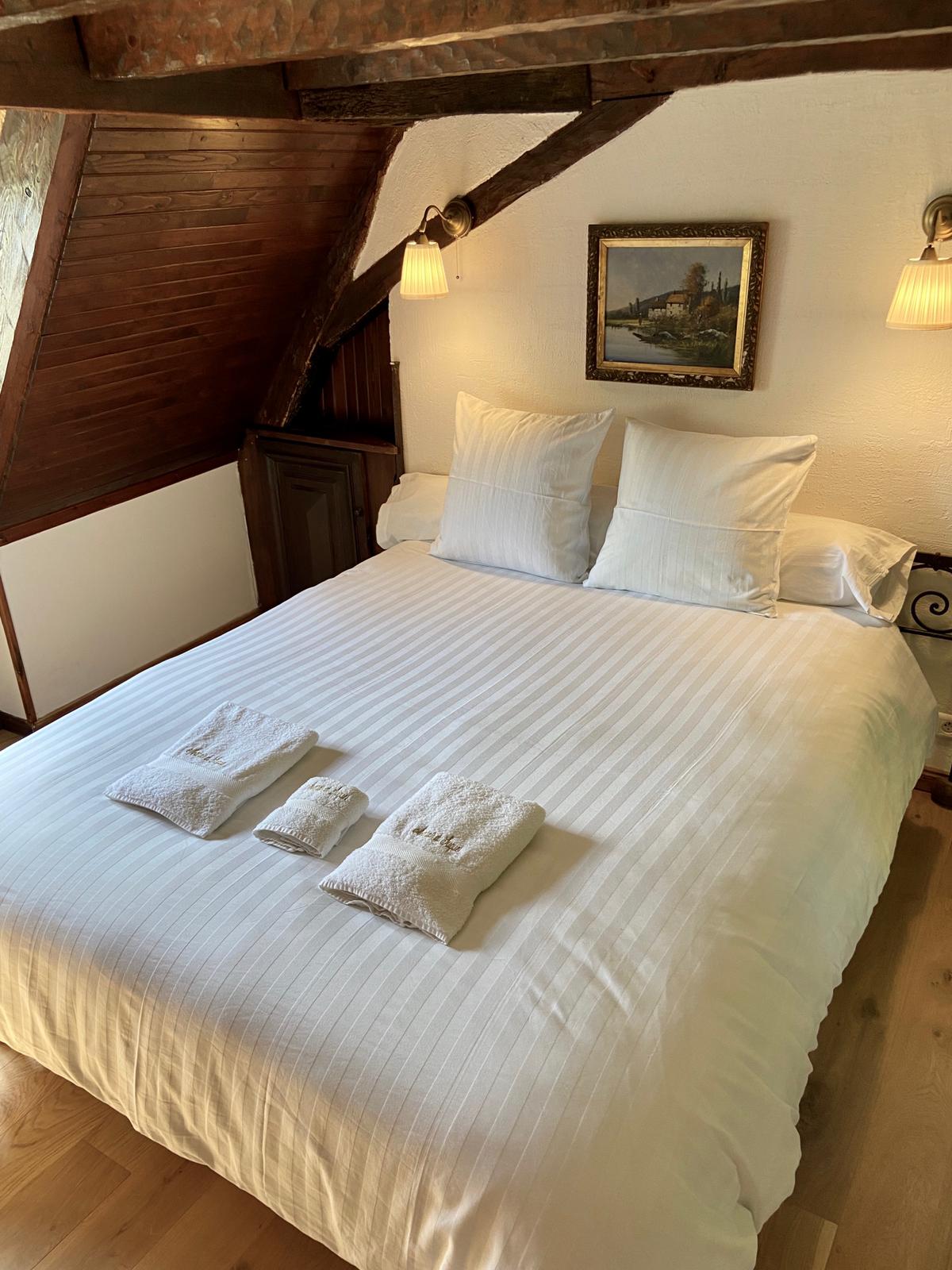 Bedroom two at Maison du Seigneur, under exposed roof timbers