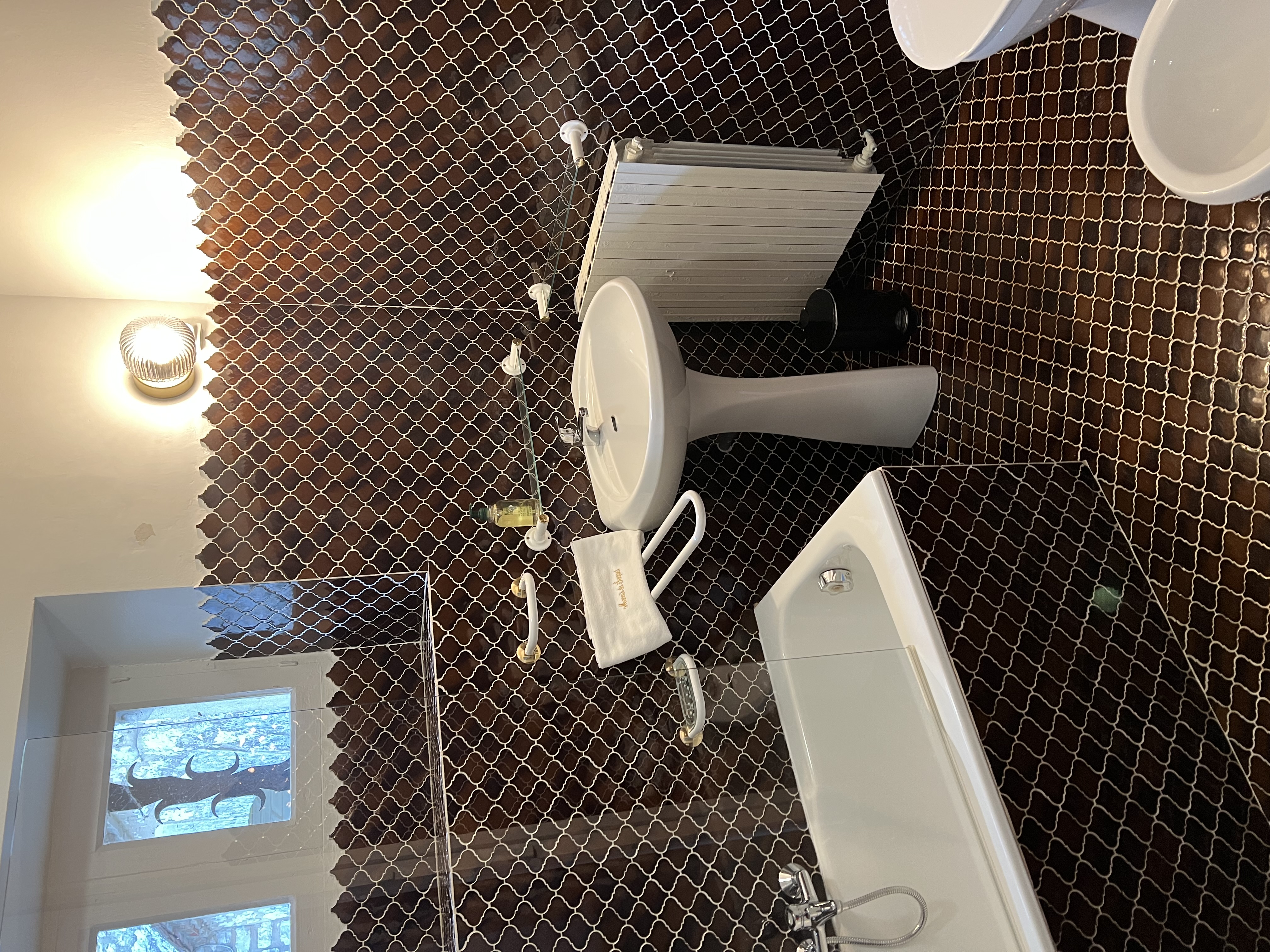 The zellige-tiled bathroom en suite to the master bedroom