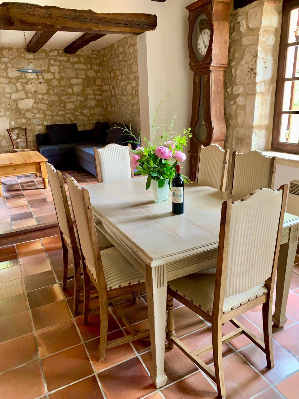 The dining room at Maison des Artistes, with a longcase clock and painted table for six