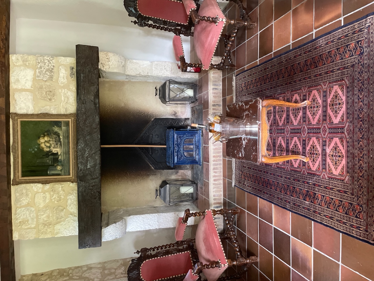 The blue enamelled wood burner in its stone hearth at Maison des Artistes