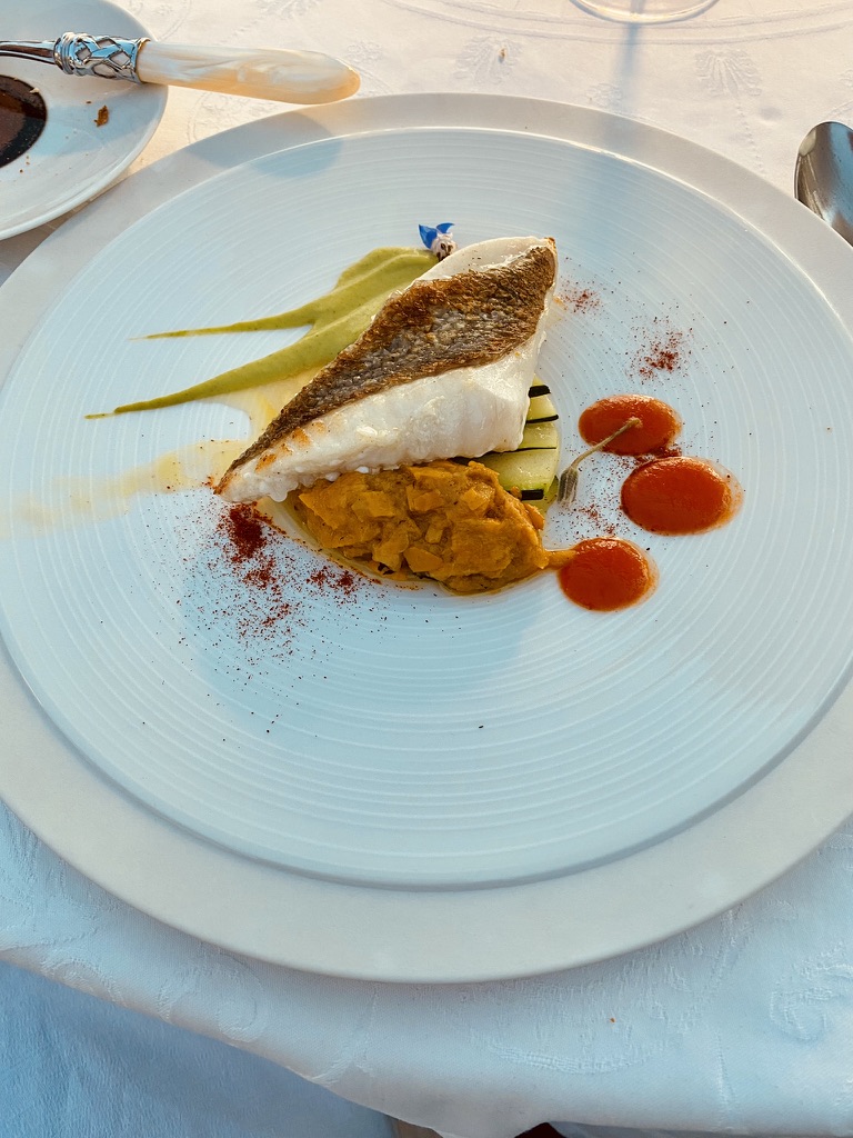 A pan-fried fish fillet at Bignac with crispy skin, pumpkin purée, courgette ribbons, pea coulis, three dots of red pepper coulis, paprika dust.