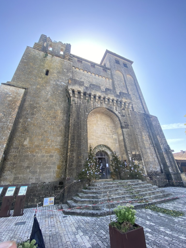 The fortified twelfth-century abbey at Saint-Avit-Sénieur, dramatic upward angle, cobbled square below.