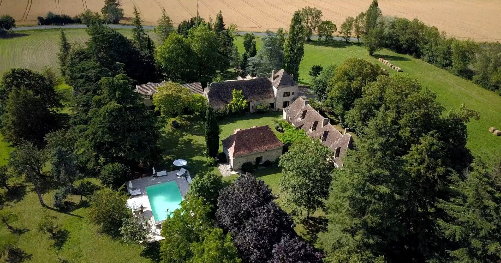 Aerial view of the Manoir du Suquet estate — the houses, pool and gardens surrounded by fields, Bardou, Dordogne