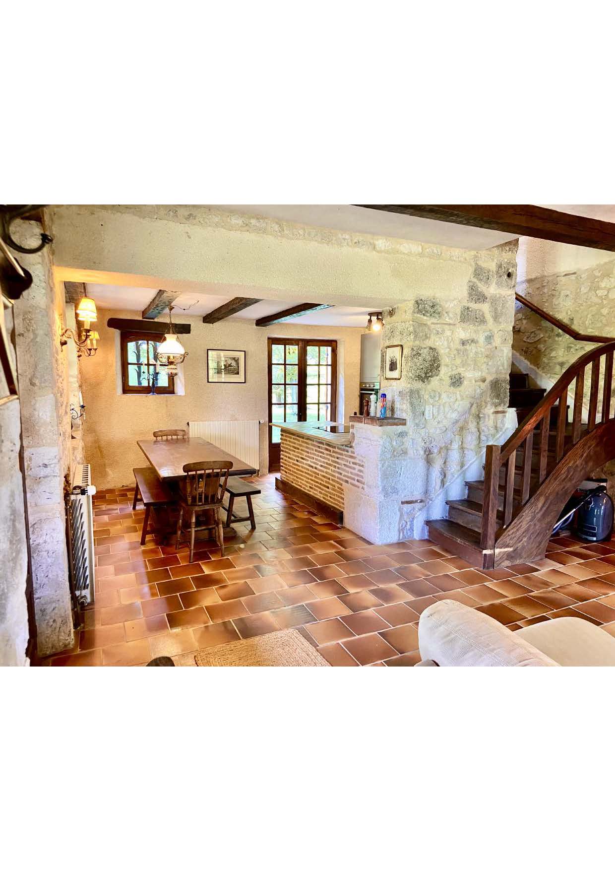 The dining room and kitchen bar at Maison des Tournesols, with the staircase beyond