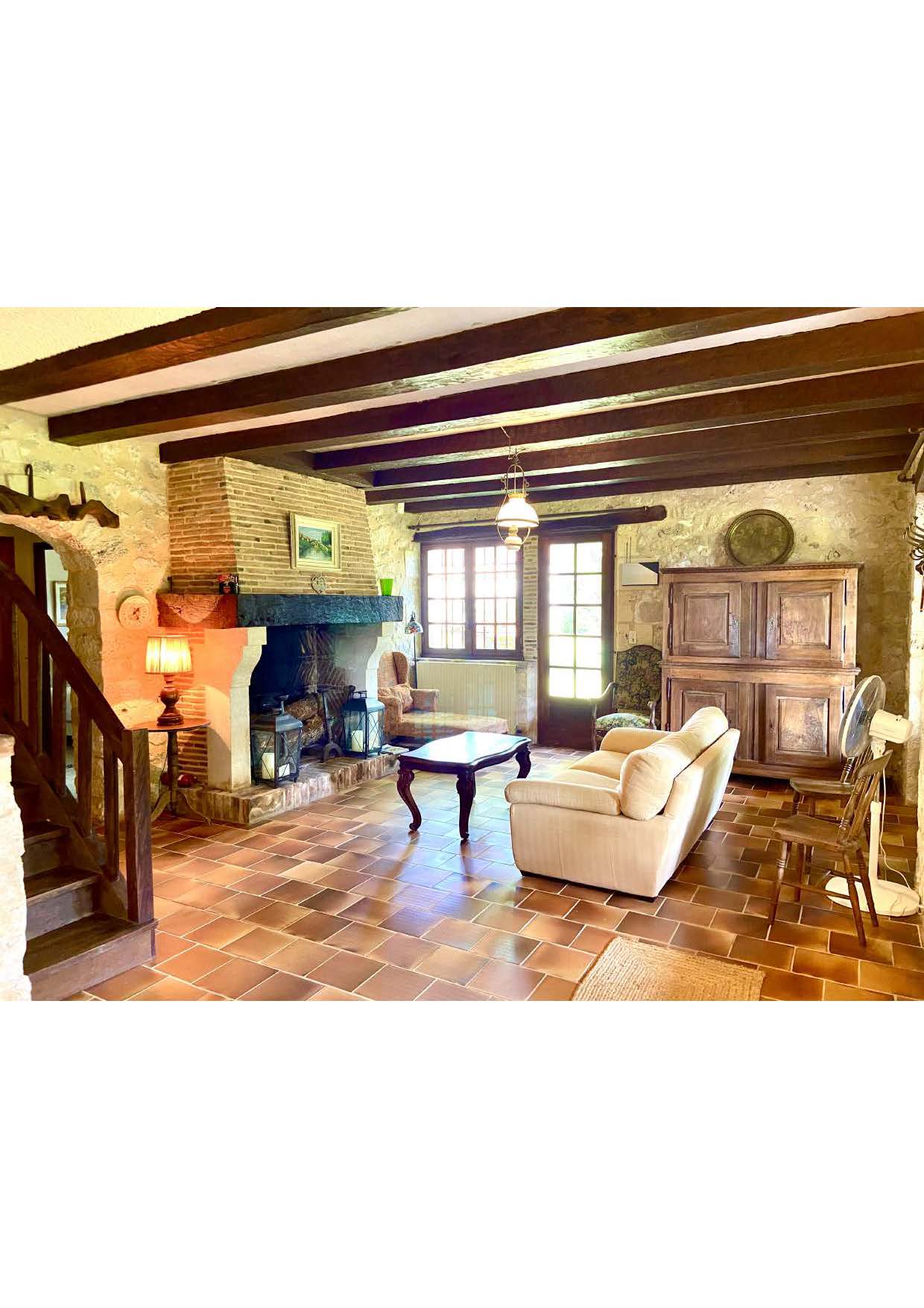 The lounge at Maison des Tournesols, with its brick chimney breast and wood burner