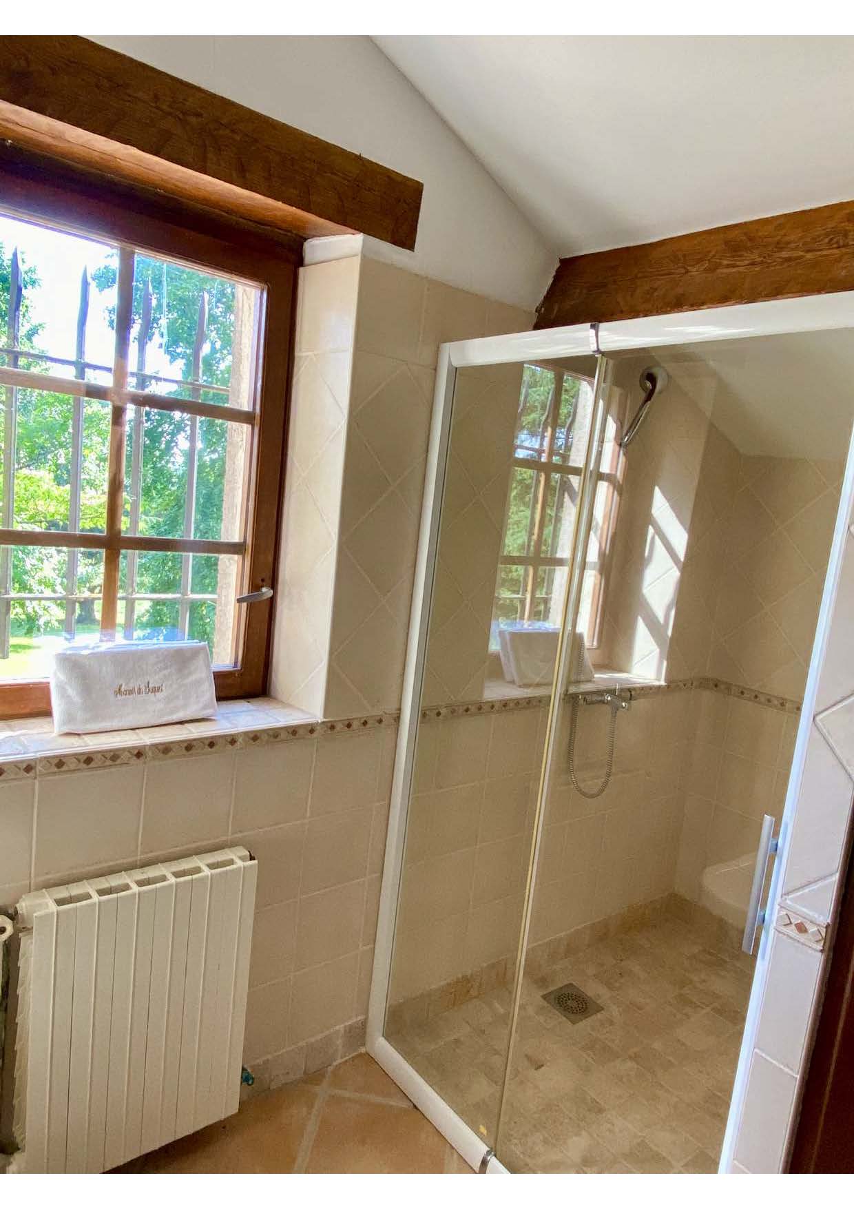 The first-floor shower room at Maison des Tournesols, with a window over the park