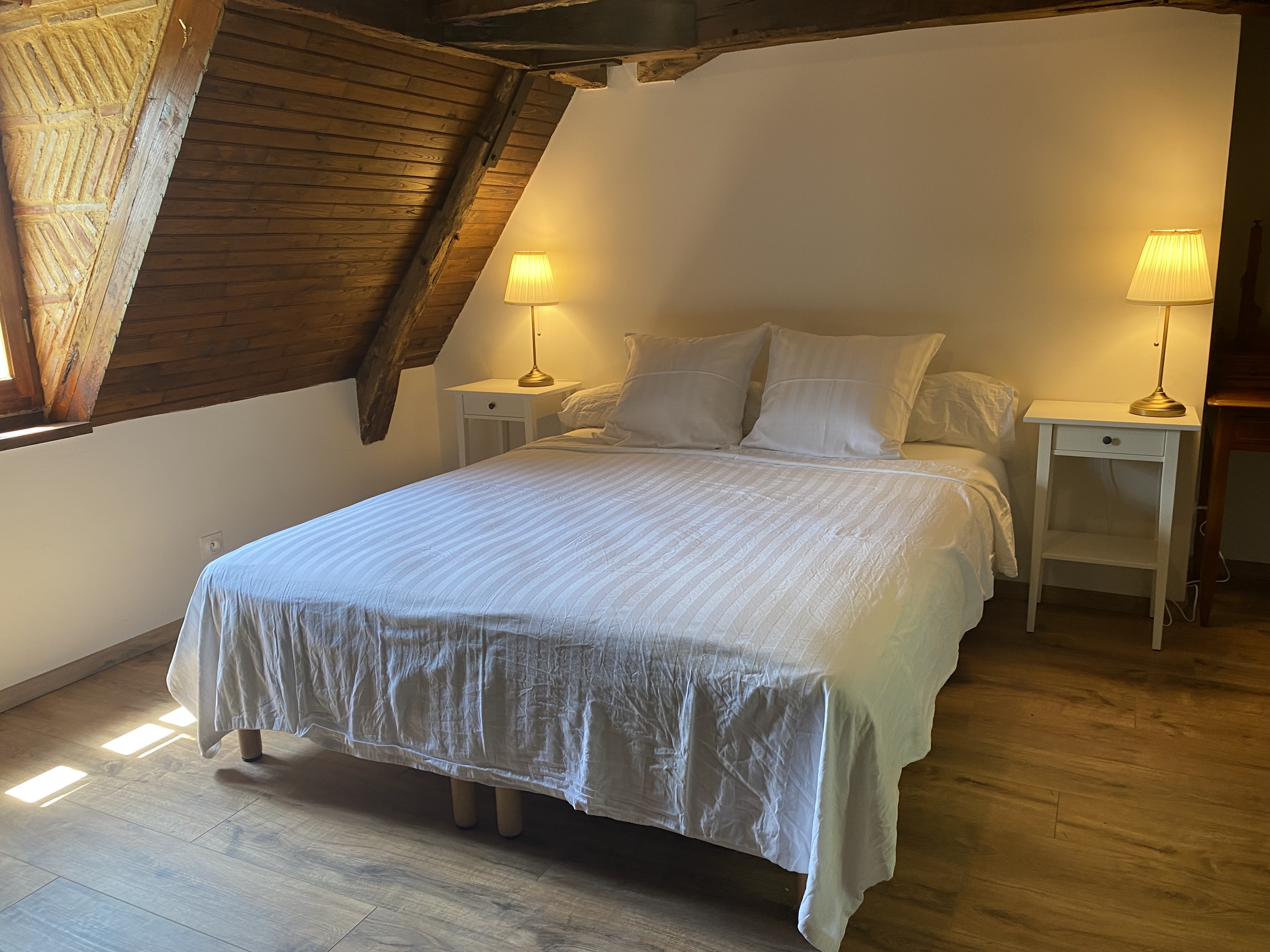 A first-floor bedroom at Maison des Vignes, under panelled eaves