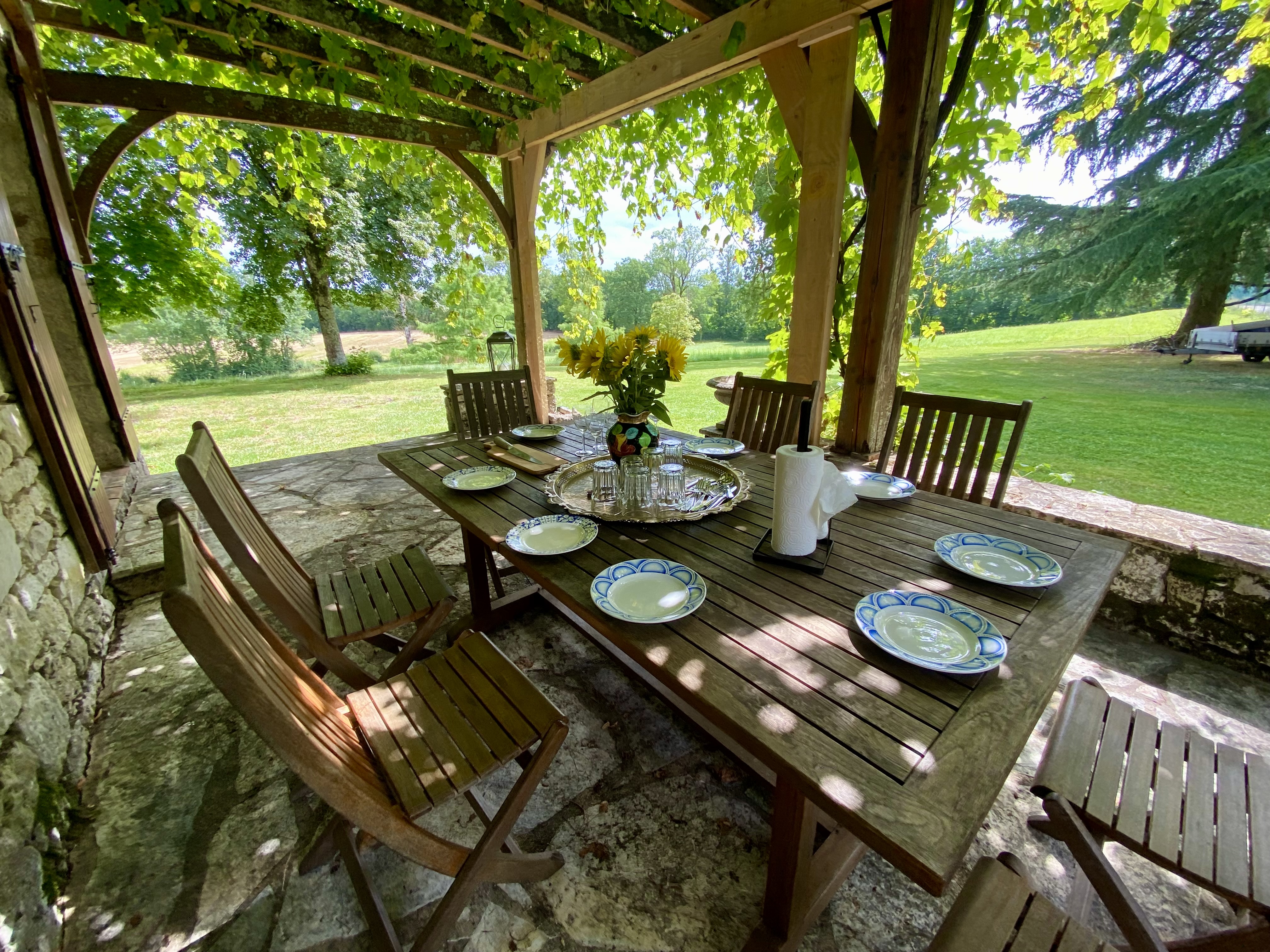 The porch table at Maison des Vignes laid for lunch, looking out over the fields
