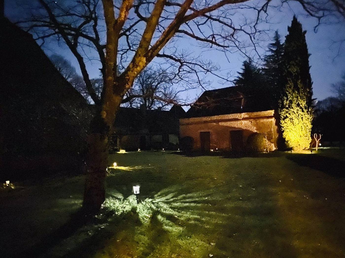 The stone house lit up at night